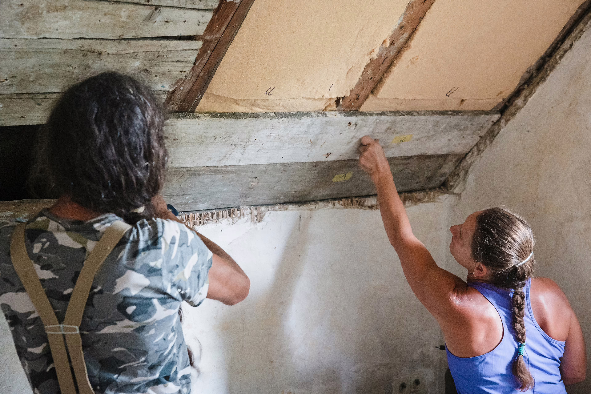 Galina und einer ihrer Handwerker arbeiten bei der Dämmung des Daches Sektion nach Sektion ab.