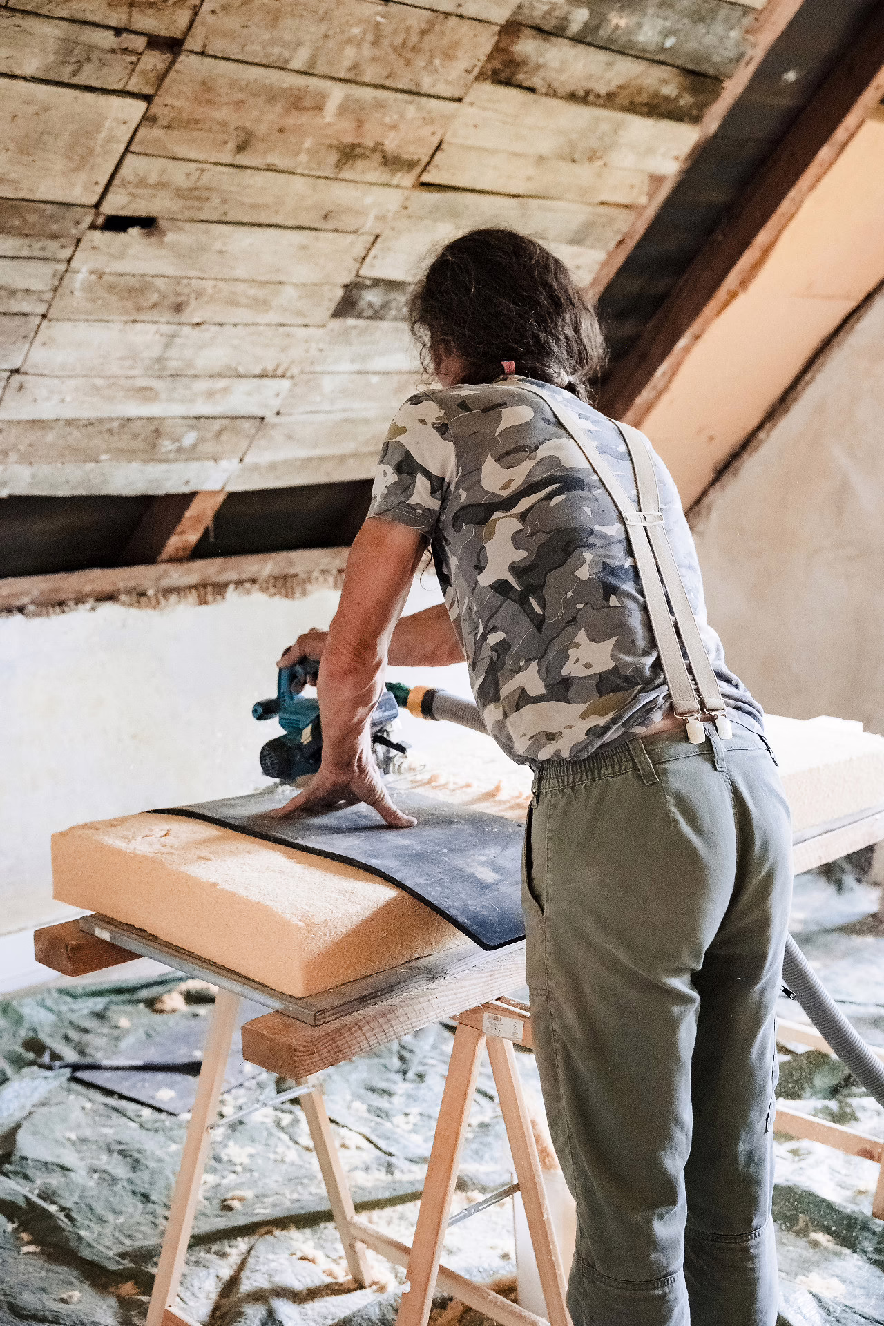Handwerker schneidet Dämmmaterial zurecht