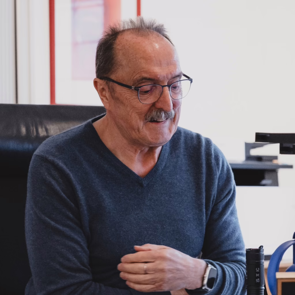 Bruno sitzt auf seinem Schreibtisch und schaut in seine Unterlagen. 